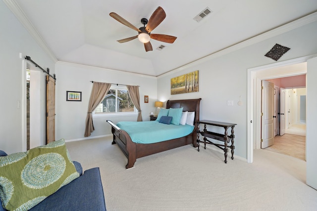 carpeted bedroom featuring a tray ceiling, baseboards, visible vents, and a barn door