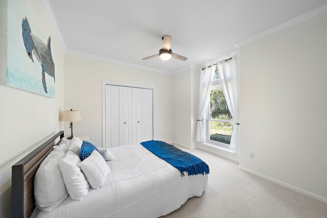 bedroom with a closet, carpet flooring, baseboards, and crown molding