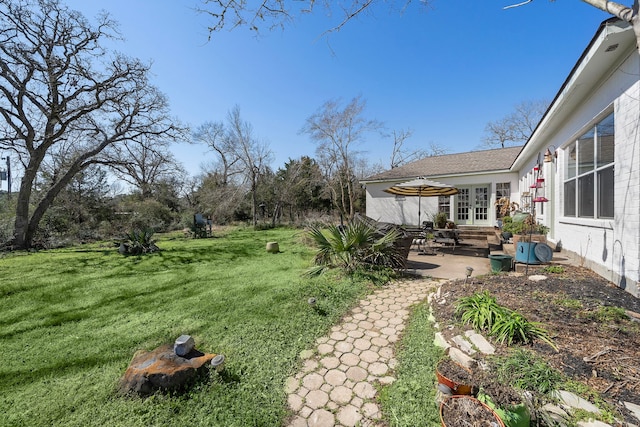 view of yard with entry steps, french doors, and a patio area