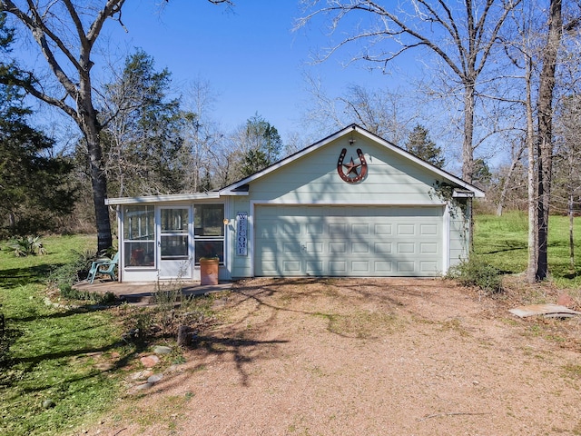 view of front of house with a sunroom, driveway, and a garage