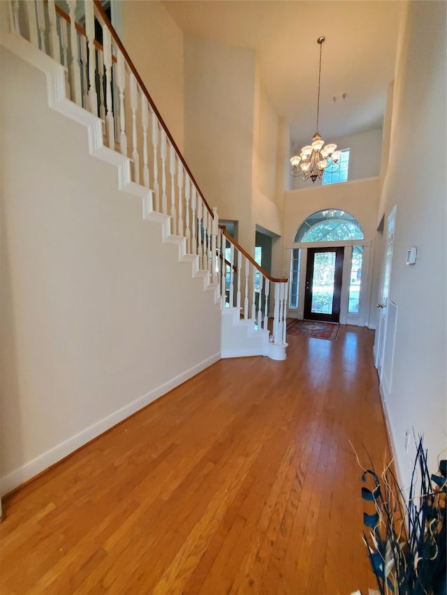 4810 N Pine Brook Way, Houston, TX 77059 - entryway featuring hardwood / wood-style floors, stairway, a chandelier, a towering ceiling, and baseboards