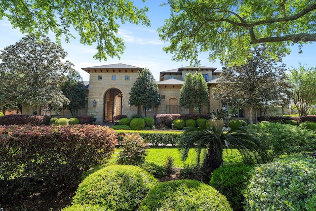 mediterranean / spanish-style home with stone siding