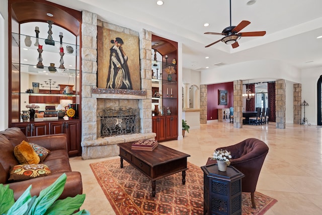 living area featuring arched walkways, a fireplace, a ceiling fan, and recessed lighting