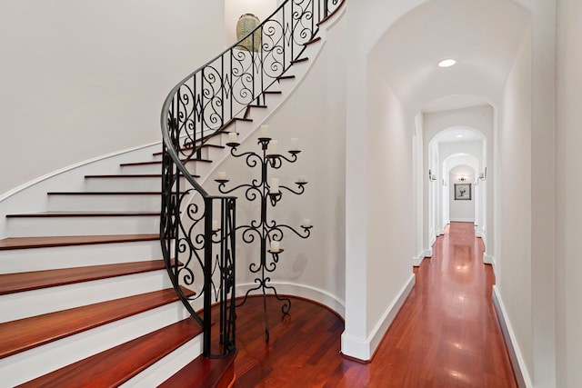 interior space featuring arched walkways and wood finished floors