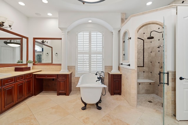 bathroom with a soaking tub, decorative columns, a stall shower, and vanity