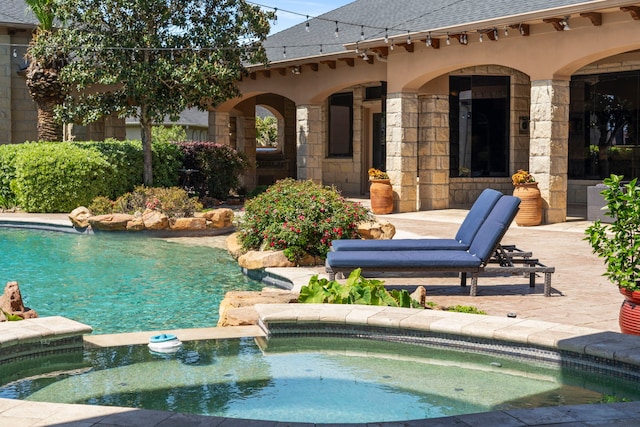 exterior space featuring a patio area and a pool with connected hot tub