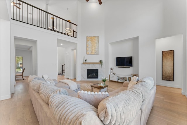 living area featuring ceiling fan, a high ceiling, and wood finished floors