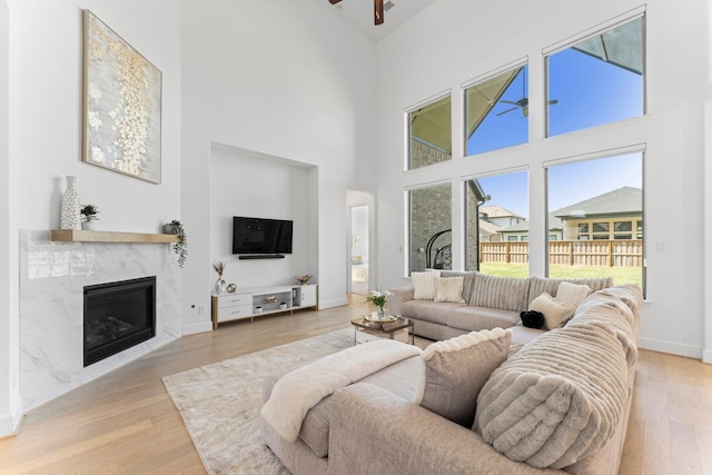 living room with light wood-style flooring and a high ceiling