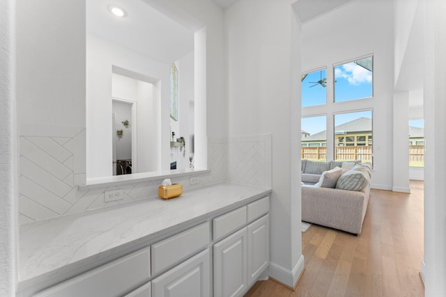 bathroom with baseboards, recessed lighting, a ceiling fan, decorative backsplash, and wood finished floors