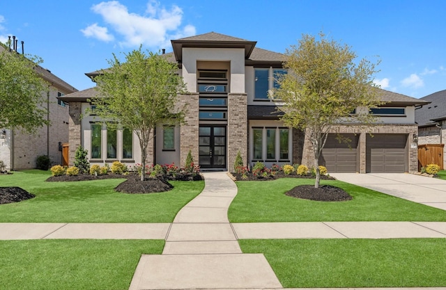 prairie-style home with a shingled roof, driveway, a front yard, and brick siding