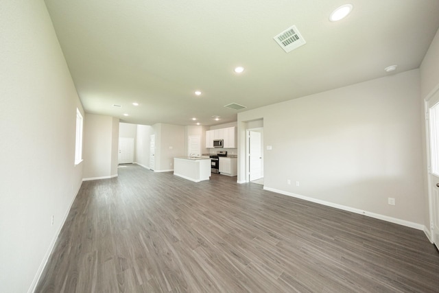 unfurnished living room with baseboards, recessed lighting, and visible vents