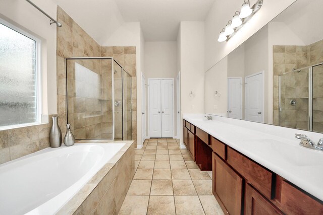 bathroom featuring a wealth of natural light, a shower stall, a garden tub, and a sink