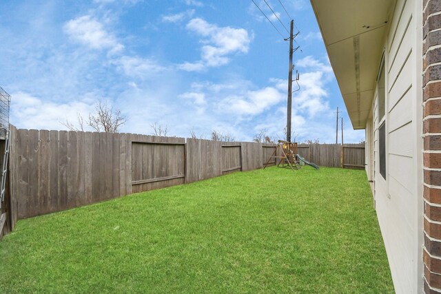 view of yard featuring a playground and a fenced backyard