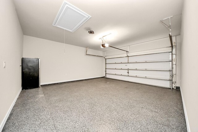 garage with a garage door opener, freestanding refrigerator, and baseboards