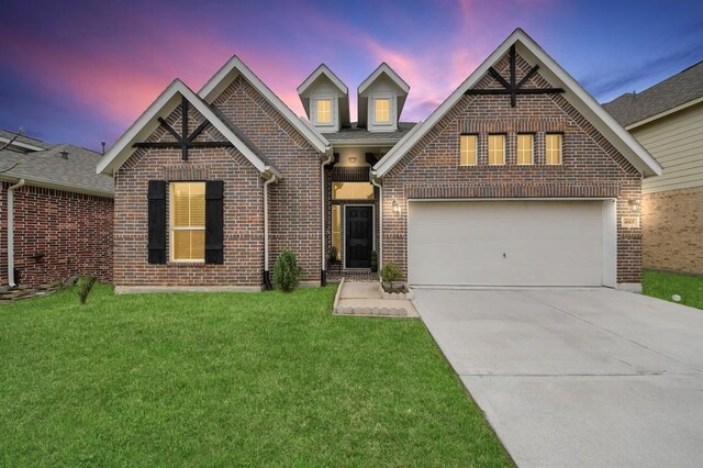 view of front of property with brick siding, a front lawn, concrete driveway, and roof with shingles