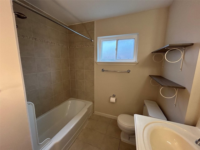 bathroom with baseboards, tile patterned floors, toilet, shower / bathing tub combination, and a sink