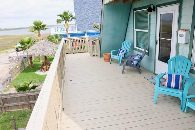 wooden deck featuring a fenced backyard, a water view, and a gazebo