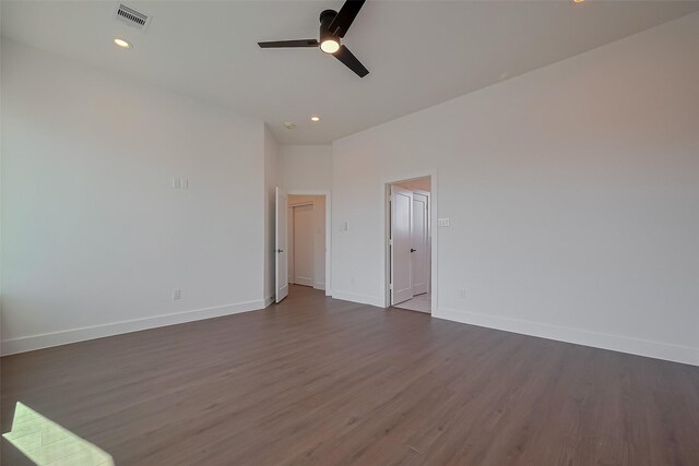 empty room featuring ceiling fan, baseboards, dark wood-style flooring, and visible vents
