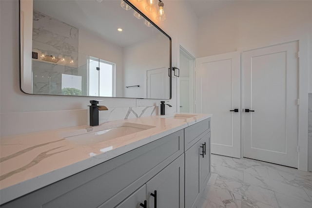 bathroom with double vanity, marble finish floor, a sink, and a marble finish shower