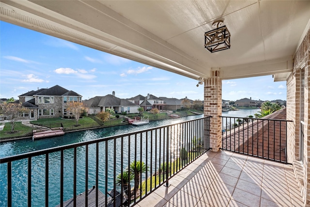 balcony with a residential view and a water view