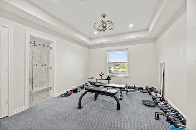exercise area featuring baseboards, a raised ceiling, an inviting chandelier, carpet, and recessed lighting
