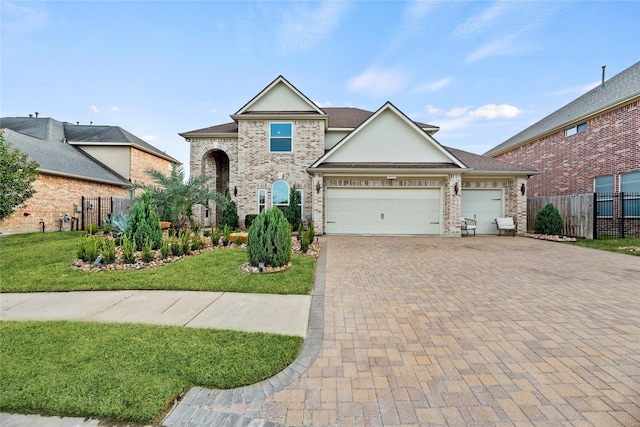 view of front facade featuring a front lawn, fence, a garage, and decorative driveway