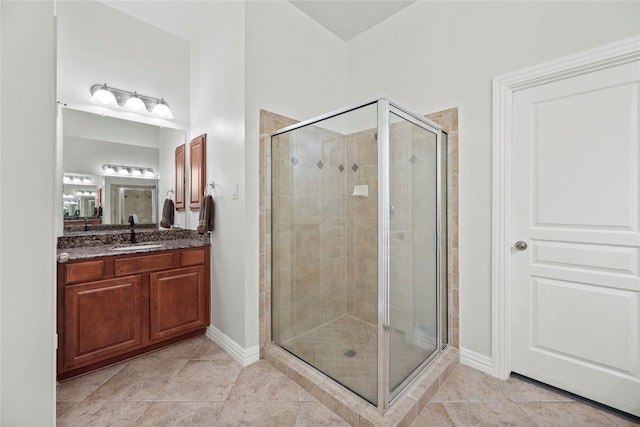 full bathroom with tile patterned flooring, baseboards, a stall shower, and vanity