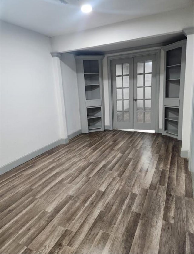 unfurnished bedroom with dark wood-style flooring, french doors, and baseboards
