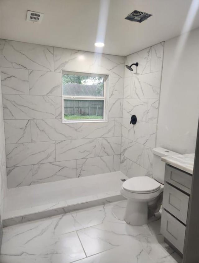 bathroom with vanity, visible vents, toilet, marble finish floor, and a stall shower