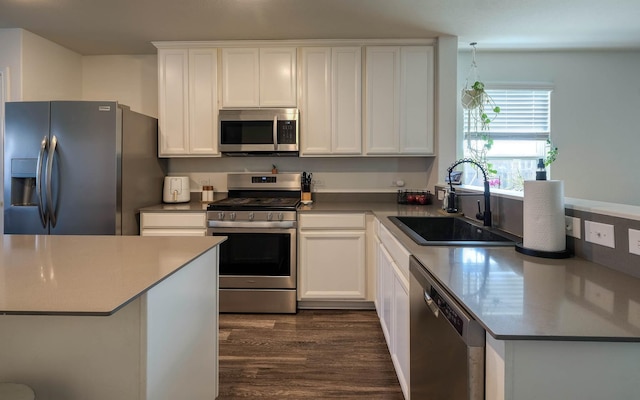 kitchen with a sink, white cabinetry, dark wood-type flooring, and stainless steel appliances