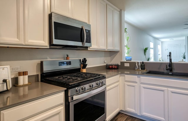kitchen featuring a sink, white cabinets, and stainless steel appliances