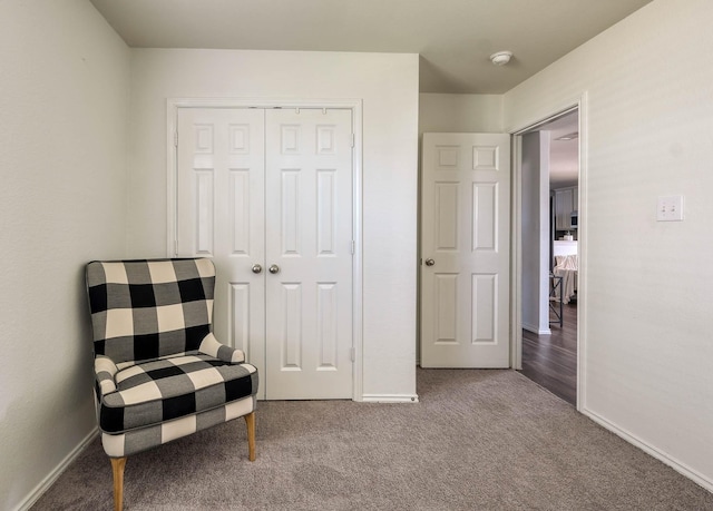sitting room featuring carpet flooring and baseboards
