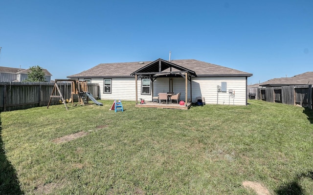 back of house featuring a gazebo, a fenced backyard, a playground, and a yard
