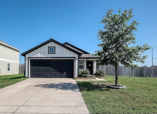 view of front facade featuring a front yard, an attached garage, board and batten siding, fence, and concrete driveway