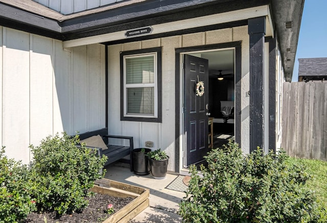 doorway to property with board and batten siding and fence