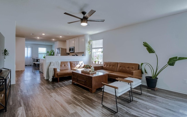 living area featuring wood finished floors, ceiling fan, and a wealth of natural light
