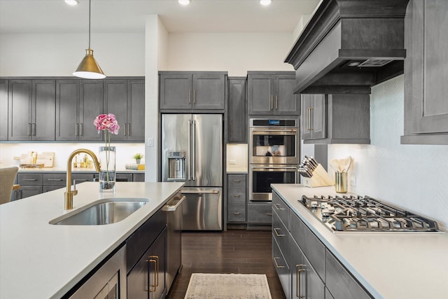 kitchen featuring custom range hood, stainless steel appliances, light countertops, and a sink