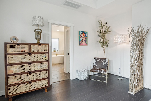 living area featuring baseboards, wood finished floors, and visible vents