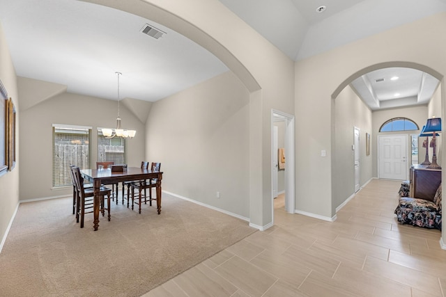 dining area featuring arched walkways, a notable chandelier, baseboards, and lofted ceiling