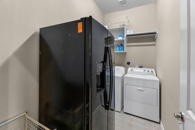 laundry room featuring light tile patterned flooring, laundry area, and washing machine and clothes dryer