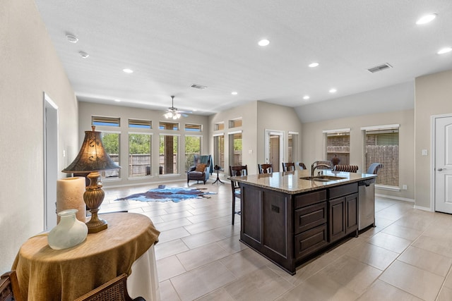 kitchen with visible vents, dishwasher, a sink, recessed lighting, and light stone counters