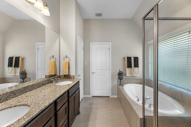 bathroom featuring a sink, visible vents, a bath, and lofted ceiling