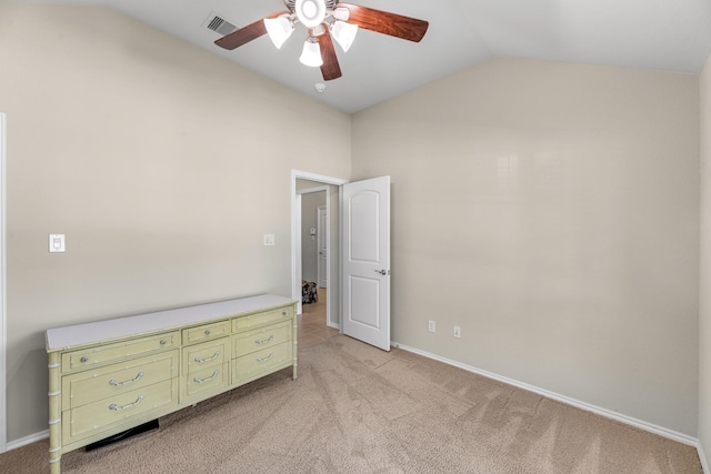 unfurnished bedroom featuring baseboards, light carpet, visible vents, ceiling fan, and high vaulted ceiling