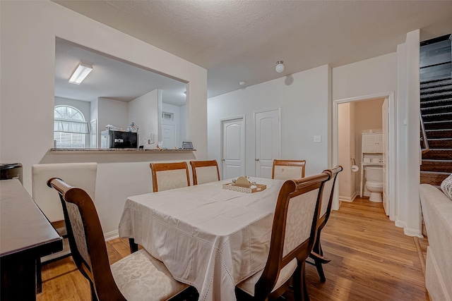 dining room featuring light wood-style flooring and baseboards