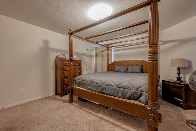 bedroom featuring visible vents, light colored carpet, and a textured ceiling