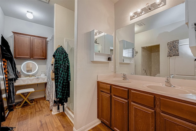 bathroom featuring a sink, visible vents, a walk in shower, and hardwood / wood-style flooring