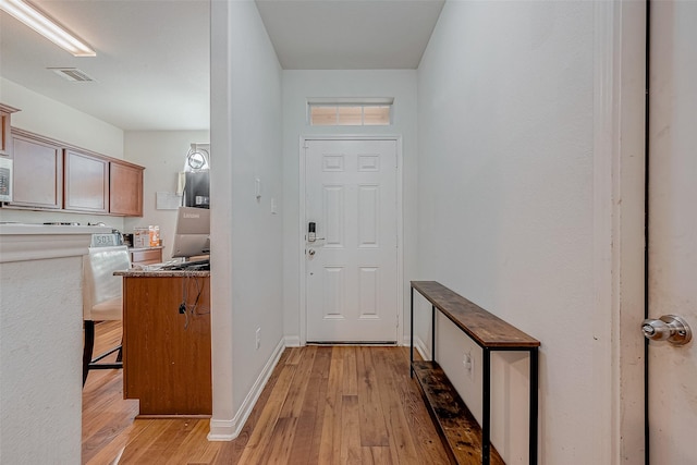 doorway featuring visible vents, baseboards, and light wood-type flooring