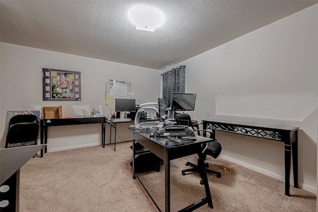 carpeted office space with a textured ceiling and baseboards