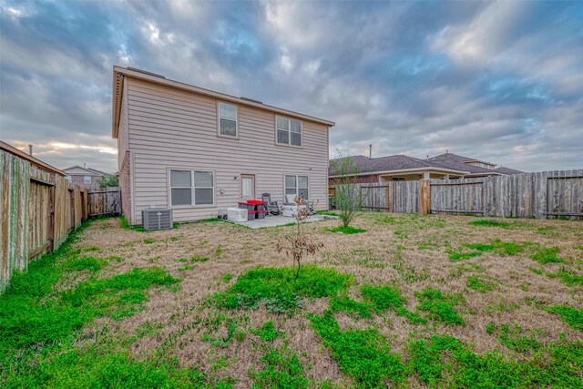 rear view of property with a patio area, a fenced backyard, and central air condition unit