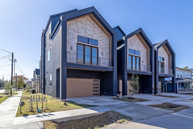 contemporary house with driveway, board and batten siding, and an attached garage